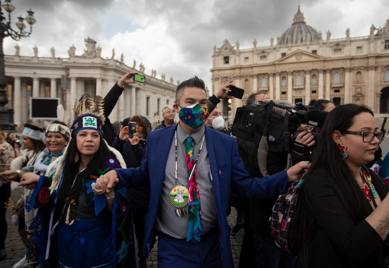 A photo of Andy Alook dancing in St. Peter’s Square in Rome Italy with a crowd of people around him.