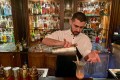 A bartender pours a drink at a bar