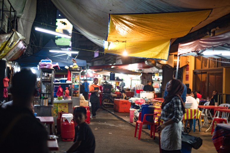 Hawkers selling food at night in the side alleys of Bukit Bintang Area in Kuala Lumpur, Malaysia.
