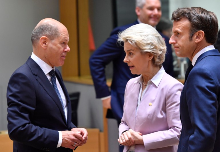 European Commission President Ursula von der Leyen, centre, and French President Emmanuel Macron, right, speak with German Chancellor Olaf Scholz during a round table meeting at an EU summit in Brussels, Thursday, June 23, 2022