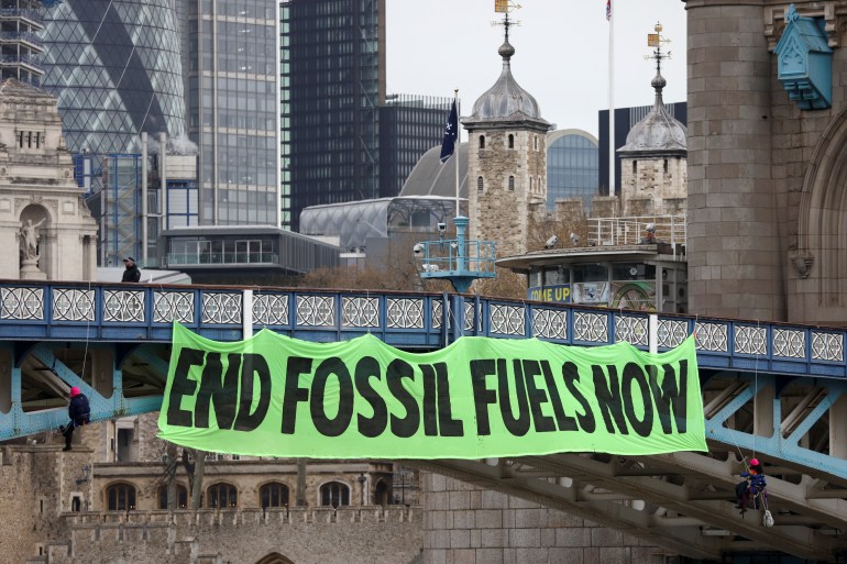 Climate change activists hang a sign on Tower Bridge during a demonstration