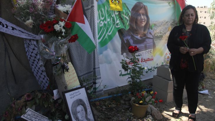 A Palestinian woman lays flowers at the site where Al-Jazeera correspondent Shireen Abu Akleh was killed in the city of Jenin in the occupied West Bank.