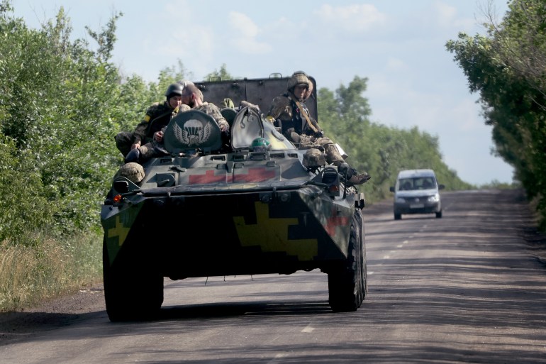 Troops board a military vehicle on June 16, 2022 near Lysychansk, 
