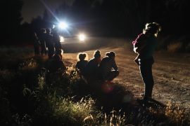 Asylum seekers wait as border agents arrive to detain them near the US-Mexico border