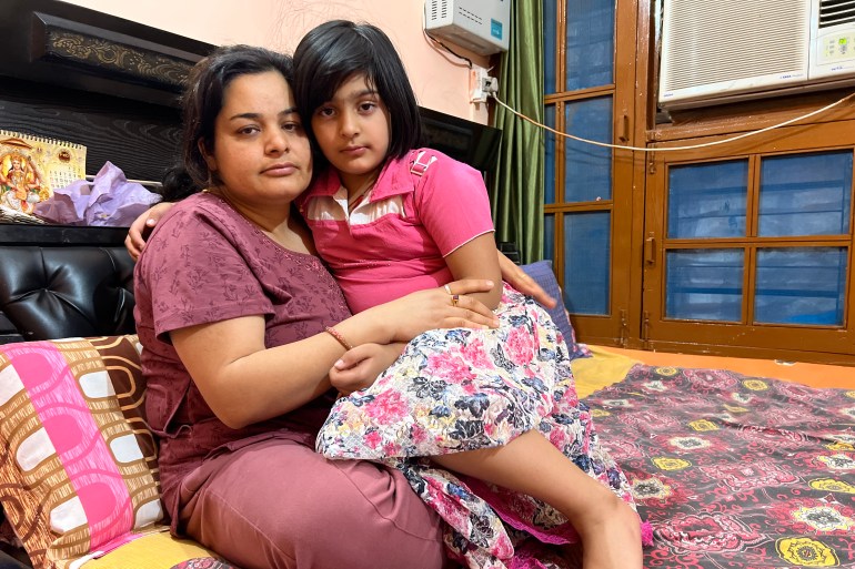 Meenakshi Bhat, wife of slain Kashmiri Hindu Rahul Bhat along with her daughter at their residence in the southern city of Jammu’s Durga Nagar.