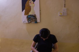 Woman bows her head in front of a picture