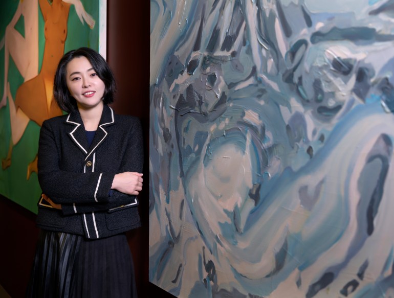 لي سو يونغ متظاهرًا أمام اللوحات الكبيرة.