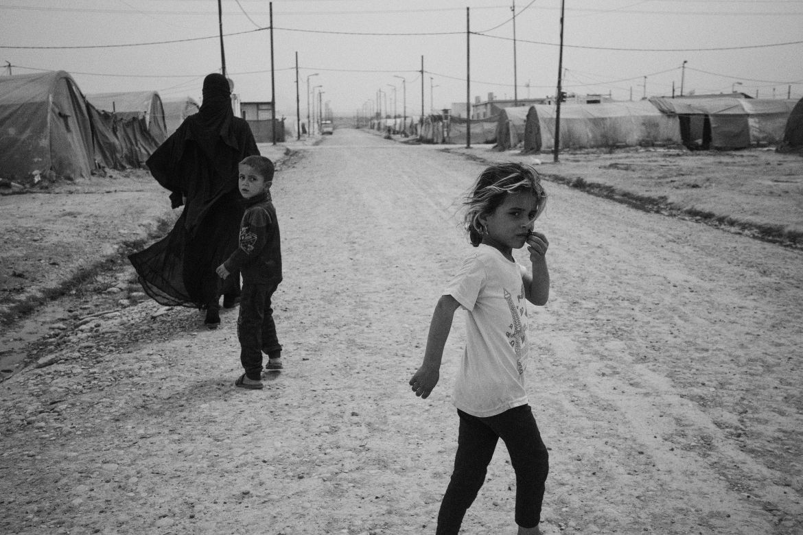 Iraq, Jeddah 5 camp. A woman and her children walk inside Jedda 5 camp.