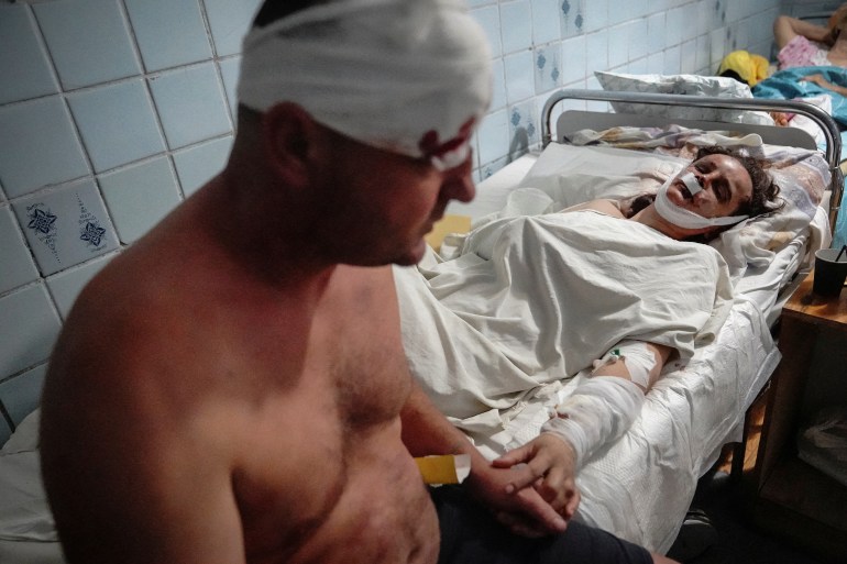 A couple wounded in a shopping mall hit by a Russian missile strike hold hands in a hospital in Kremenchuk, in Poltava region, Ukraine June 27, 2022