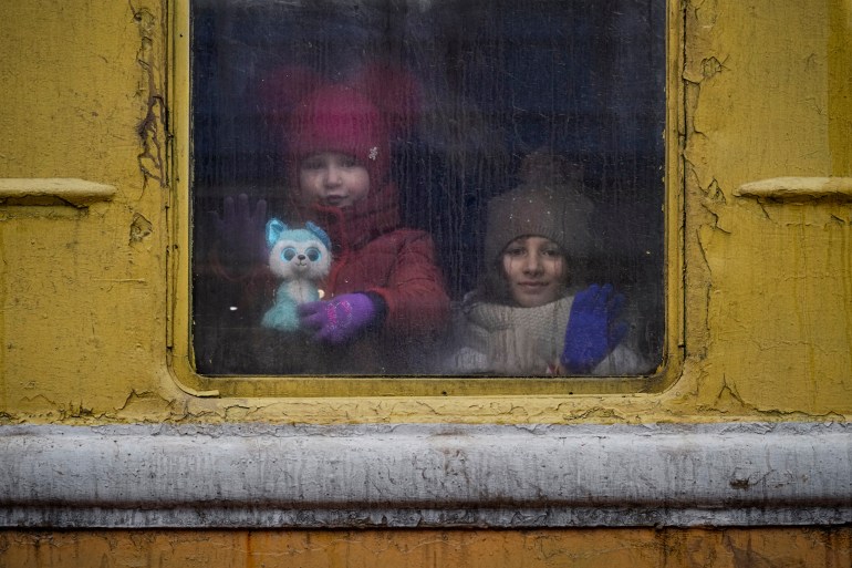 Children look out the window of an unheated Lviv-bound train, in Kyiv, Ukraine.