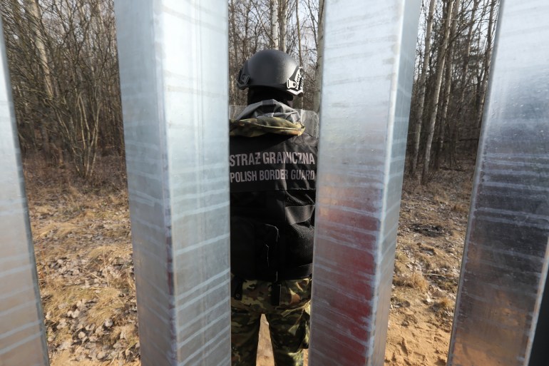 Polish Border Guard officer guards at a construction site of a border fence at the border with Belarus
