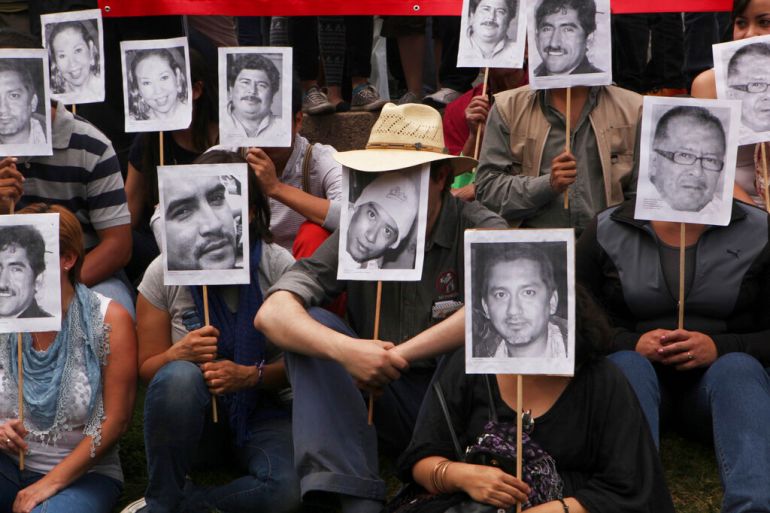 Journalists protest journalist murders by holding photos of the victims in front of their faces.