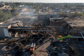 Ukrainian firefighters work to take away debris at a shopping centre burned after a rocket attack in Kremenchuk, Ukraine, Tuesday, June 28, 2022 [Efrem Lukatsky/AP]