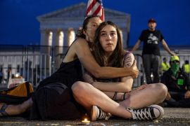 Lisa Turner,47, holds her daughter Lucy Kramer,14, during a candlelight vigil outside the United States Supreme Court in Washington, U.S.