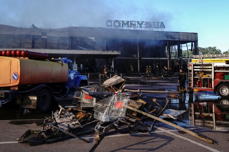 Rescuers work at a shopping mall hit by a Russian missile in Kremenchuk, Ukraine.