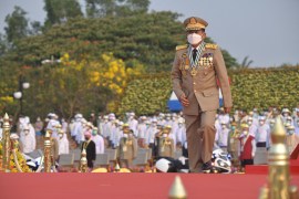 Minh Aung Hlaing in a beige coloured uniform bedecked with medals takes the stage at Myanmar's Armed Forces Day in March