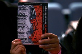 An attendee holds a book on a book on the massacre of indigenous people who were protesting living and working conditions on cotton plantations back in 1924, during a landmark trial on May 10, 2022, in Buenos Aires.
