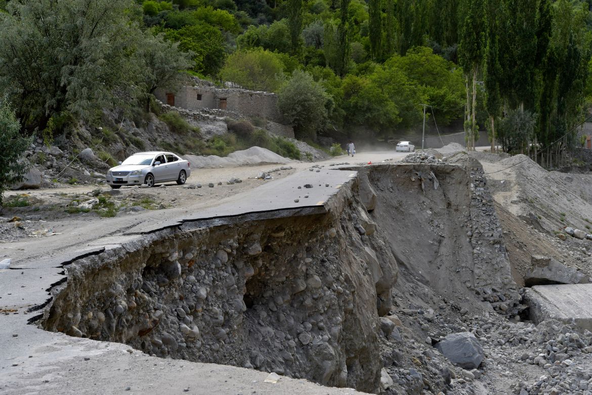 In this picture taken on June 9, 2022, a vehicle drives past a partially collapsed section of the Karakoram Highway damaged after a lake outburst because of a melting glacier, near Hassanabad village