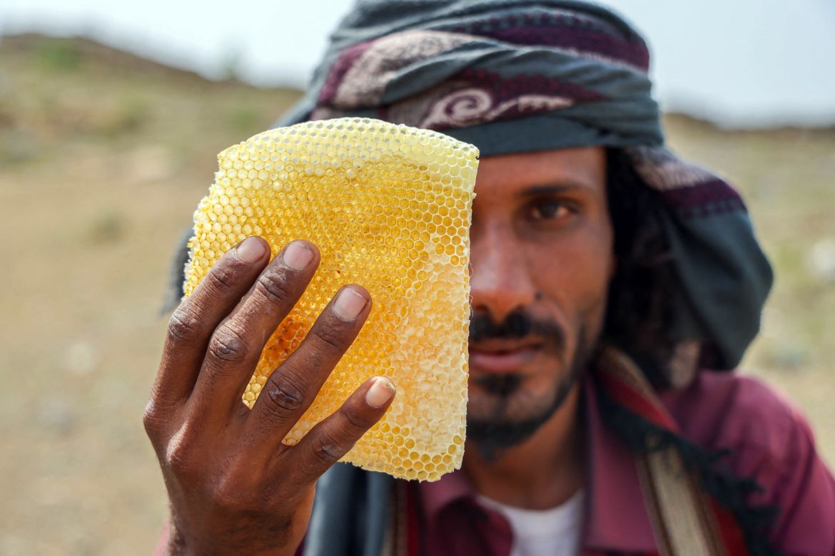 A Yemeni beekeeper shows a honeycomb