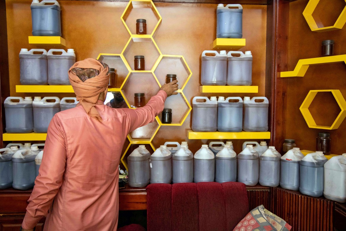 A Yemeni vendor arranges jars of honey at his shop