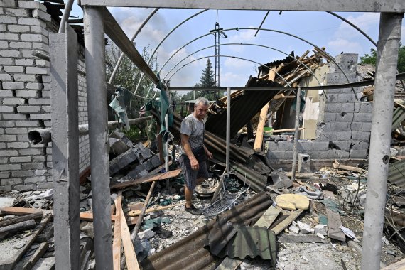 A resident walks among debris next to a destroyed house in Sloviansk