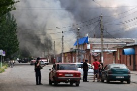 Ukrainian security personnel halt motorists as smoke rises from the central market of Sloviansk, north of Kramatosk on July 5, 2022, following a suspected missile attack amid the Russian invasion of Ukraine [Miguel Medina/AFP] (AFP)