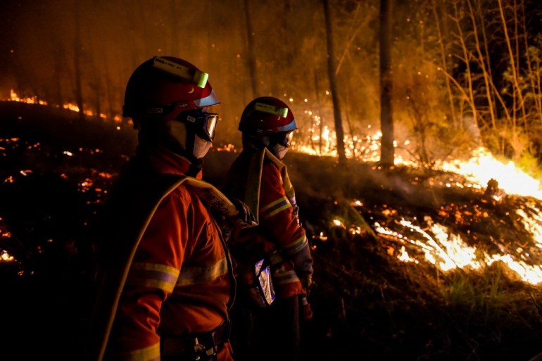 Firefighters stand by a wildfire near Besseges, southern France