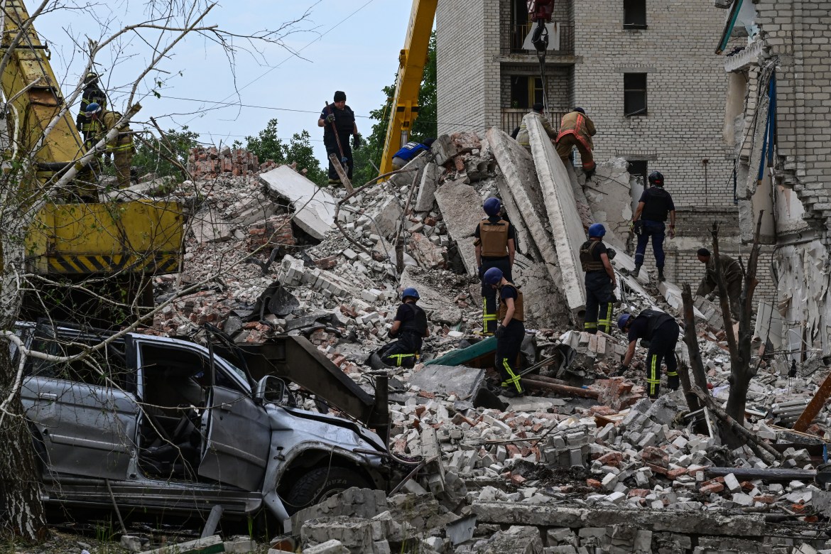 Rescuers clear the scene after a building was partialy destroyed as a result of Russian missile hit on a four-storey residential building in Chasiv Yar