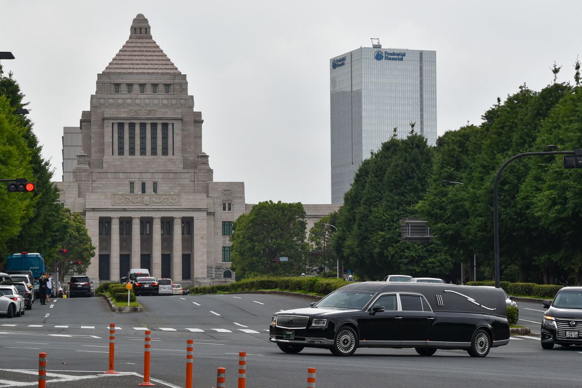 A hearse transporting the body of late former Japanese prime minister Shinzo Abe drives past the Diet Building