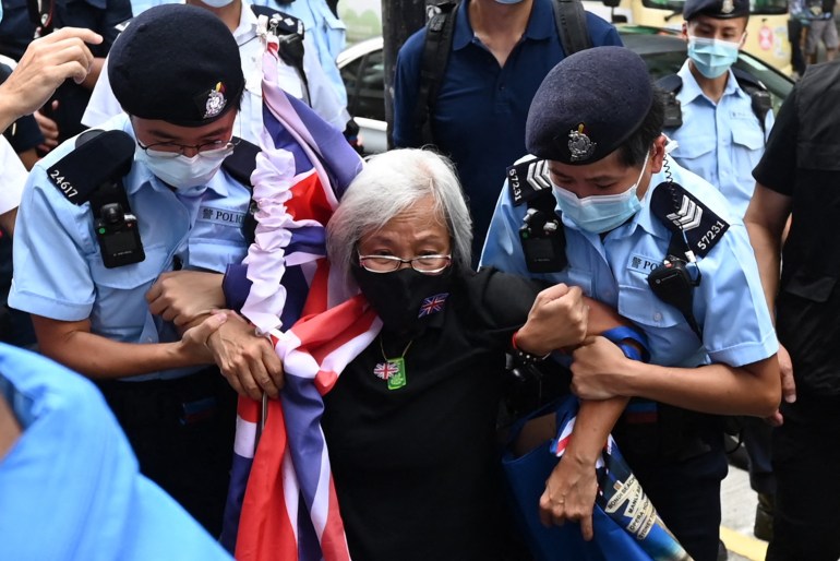 Grandma Wong, wrapped in a Hong Kong colonial-era flag, is taken away by two Hong Kong police after protesting on July 1, the day marking the territory's handover to China