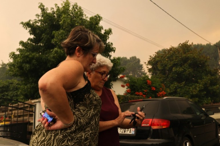 Local residents read the evacuation warning on a mobile phone in Cazaux, France