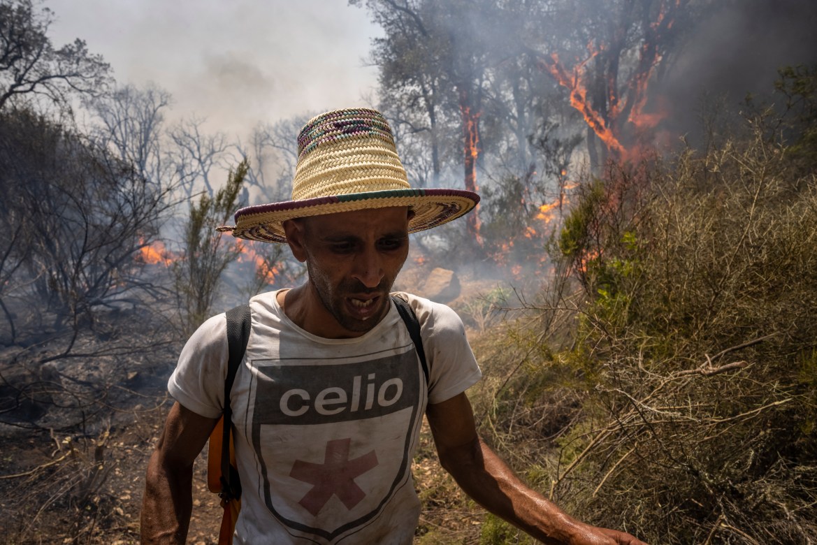 A villager reacts as a forest fire rages near Ksar el-Kebir in the Larache region