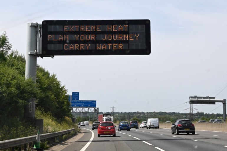 A road sign reads "Extreme Heat, Plan your journey, Carry water", warning motorists about the heatwave forecast