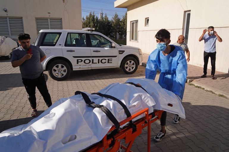 Medics transport the body of a victim following Turkish shelling in the city of Zakho in the north of Iraq's autonomous Kurdish region