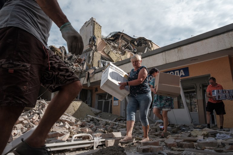 Teachers and workers carry out surviving items from their school destroyed as a result of a shelling in Bakhmut, Donetsk
