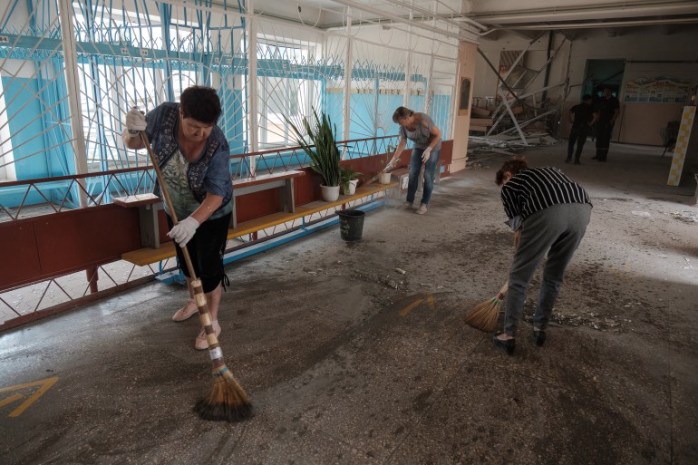 Teachers and workers clean survived part of their school destroyed as a result of a shelling in Bakhmut, Donetsk region