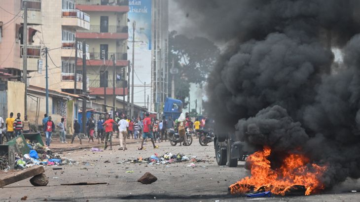 Black smoke billows into the air from a fire set during protests on the streets of Conakry