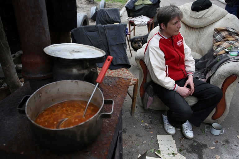 A local resident cooks a borshch, a traditional Ukrainian tomato soup, on the outskirts of eastern Ukrainian city of Donetsk on April 11, 2017. - After three years of war, Irina and her husband Arkady have all but lost hope of ever seeing the day the big guns fall silent and Ukraine becomes whole again. The middle-aged couple live in the shelled-out northern outskirts of the Russian-backed separatist rebels' de facto capital city of Donetsk in the eastern industrial heartland of the divided former Soviet state. (Photo by Aleksey FILIPPOV / AFP)