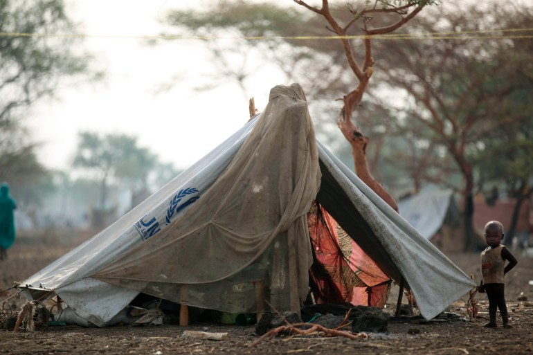 A displaced child stands outside their shelter at the Jamam refugee camp in South Sudan's Upper Nile State.