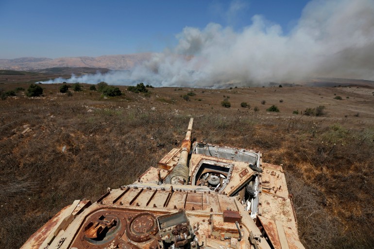 Smoke rises from a fire near an old tank in the Israeli-occupied Golan Heights.