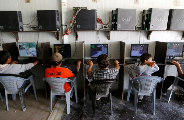 أطفال لاجئون سوريون يلعبون ألعاب الكمبيوتر في مخيم الزعتري للاجئين بالقرب من الحدود مع سوريا