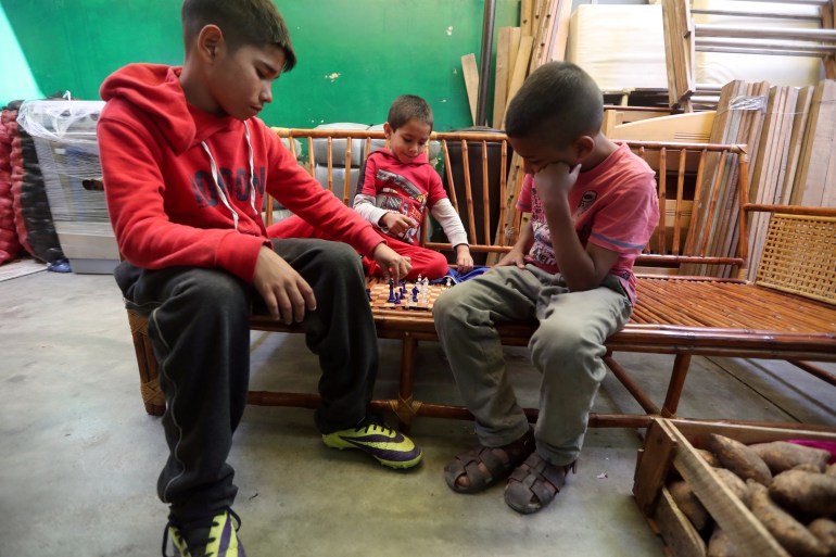 Venezuelan migrant children play chess in a temporary shelter in Peru
