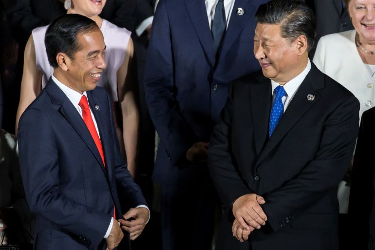 Indonesia's President Joko Widodo speaks to China's President Xi Jinping during a family photo session in front of Osaka Castle at the G-20 summit, in Osaka, Japan in June 2019.