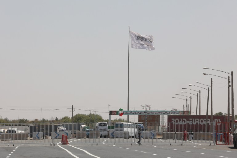 The flag of the Islamic Emirate of Afghanistan (Taliban) is pictured from the Dowqarun border crossing between Iran and Afghanistan
