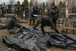 Funeral service employees and police investigators around the bodies of civilians killed in the Russian invasion of Ukraine.