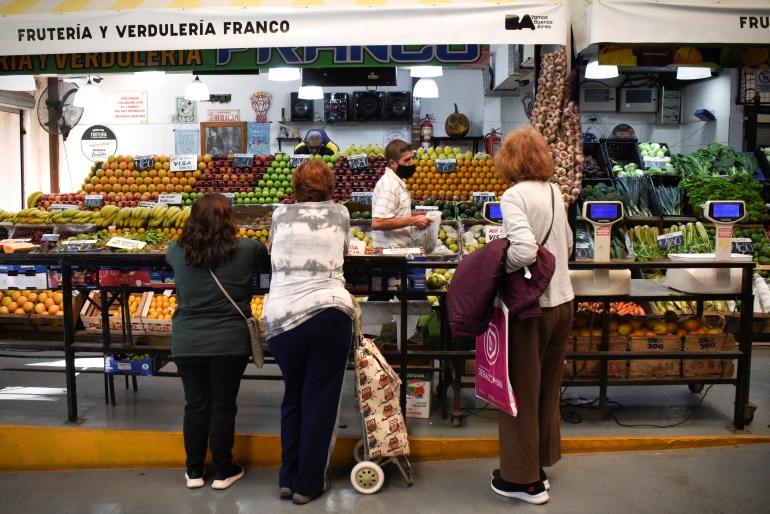 Customers line up to buy produce in a market as inflation in Argentina hits its highest level in years.