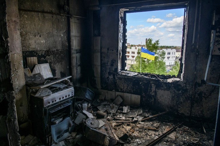 The Ukrainian national flag is seen through the window of an apartment destroyed during Russia's invasion of Ukraine in the town of Borodianka, in Kyiv region.