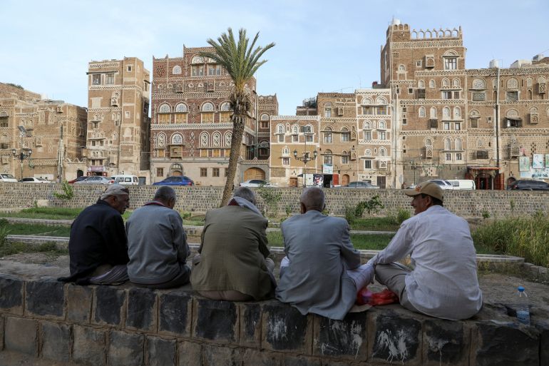People sit in front of houses in the old city of Sanaa, Yemen June 15, 2022. Picture taken June 15, 2022.
