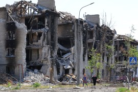 Residents walk past apartment buildings destroyed during the Ukraine-Russia conflict in the city of Severodonetsk in the Luhansk region, Ukraine [File: Alexander Ermochenko/Reuters]