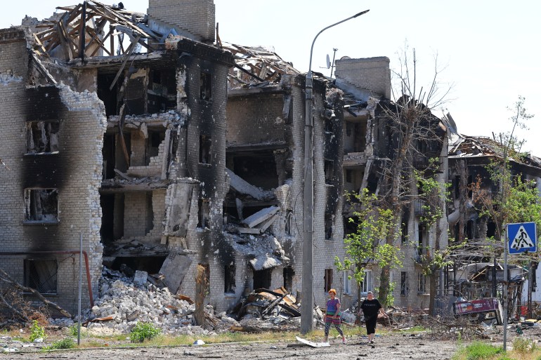 Local residents walk past apartment buildings destroyed during Ukraine-Russia conflict in the city of Sievierodonetsk in the Luhansk Region, Ukraine June 30, 2022